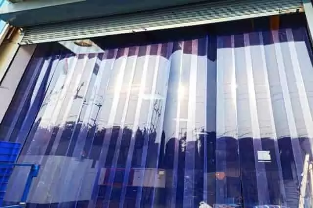 PVC szalagfüggöny bejárati ajtóra – átlátszó ipari ajtófüggöny raktárbejárathoz